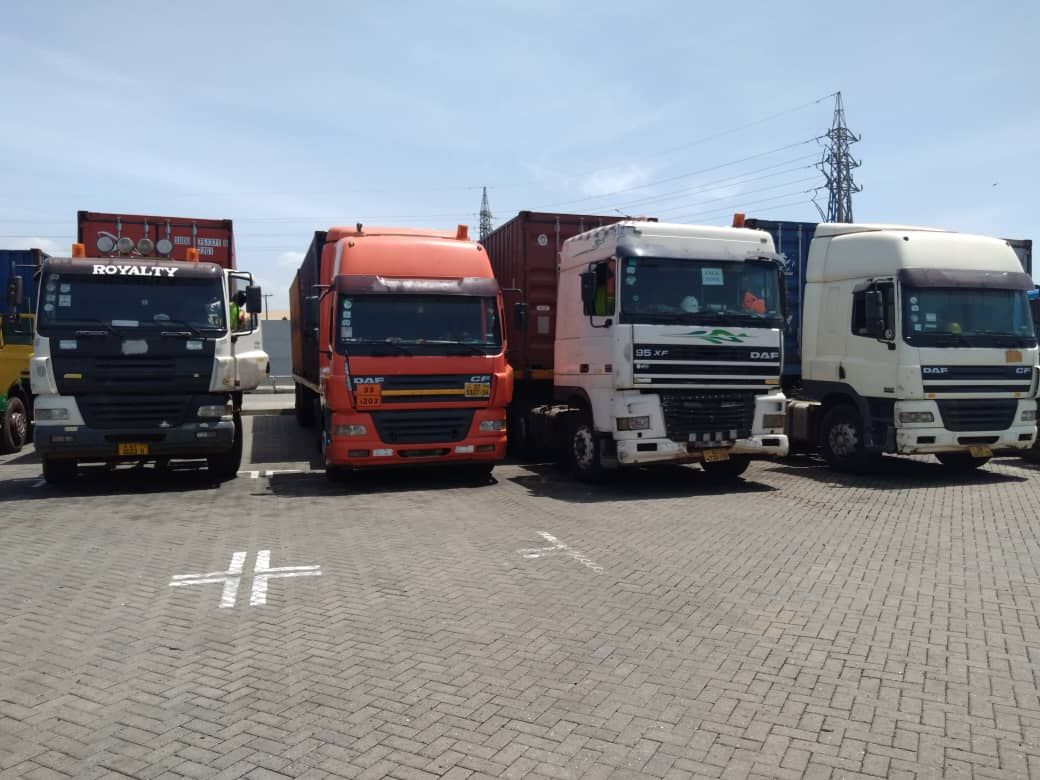 Four DAF tractor units parked in a row at a container terminal